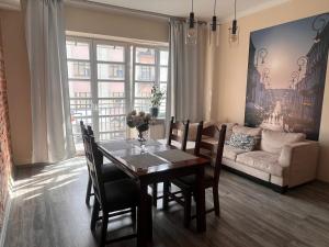 a dining room with a table and a couch at Apartamenty Azzurro in Kielce