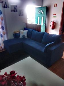 a blue couch in a living room with a mirror at Casa dos Valentes in Santo Espírito