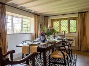 a dining room with a long table and chairs at Thatch on the Green in Great Tew