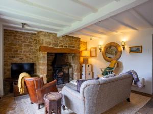 a living room with a couch and a fireplace at Thatch on the Green in Great Tew