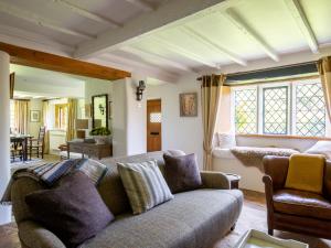 a living room with a couch and a table at Thatch on the Green in Great Tew
