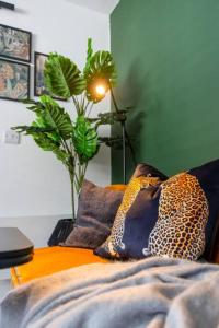 a bedroom with a bed with pillows and a plant at Stylish Cardiff City Apartment with Parking in Cardiff