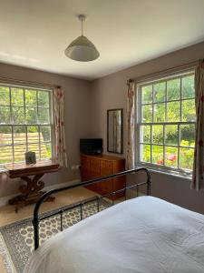 1 dormitorio con 1 cama, vestidor y 2 ventanas en Starnash Farmhouse Holiday Home, en Hailsham