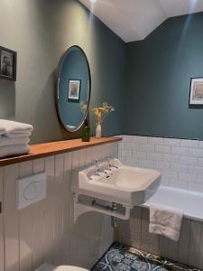 La salle de bains est pourvue d'un lavabo, d'un miroir et d'une baignoire. dans l'établissement Starnash Farmhouse Holiday Home, à Hailsham