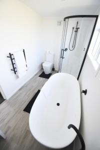 baño blanco con aseo blanco y ducha en Premium Comfortable Lake View 2BR en Taupo