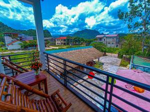 balkon ze stołem i krzesłami oraz basenem w obiekcie YoLo Pool Bar Villas w mieście Phong Nha
