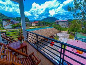 a balcony with a table and chairs and a pool at YoLo Pool Bar Villas & Garden Restaurant in Phong Nha