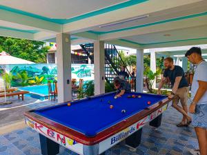 a group of people standing around a pool table at YoLo Pool Bar Villas & Garden Restaurant in Phong Nha
