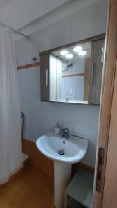 y baño con lavabo blanco y espejo. en AGNANTIO HOME, en Monemvasia