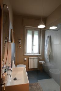 baño con lavabo y aseo y ventana en Appartamento Doria [5 minuti a piedi dal mare], en Andora