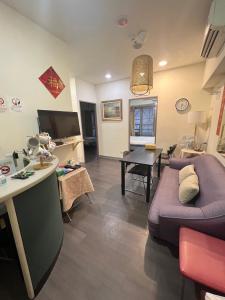 ein Wohnzimmer mit einem Sofa und einem Tisch in der Unterkunft 果芒驛站旅店 in Taipeh