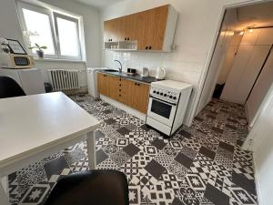 kuchnia z biało-czarną podłogą wyłożoną kafelkami w obiekcie Apartment YuPa w Koszycach