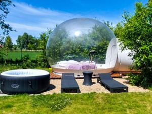 a bubble in a garden with a bath tub and a ball at W BAŃCE Glamping in Łódź