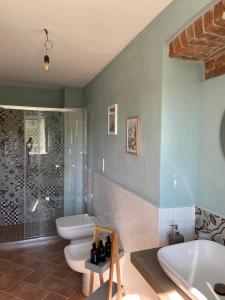 a bathroom with two toilets and a tub and a shower at Casa Quinterni in Alba
