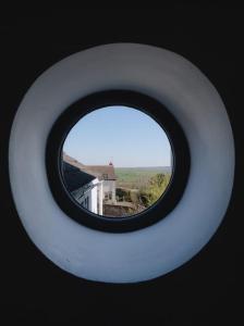 a round window with a view of a house at The Old Sweet Shop, 4 Bedroom House 