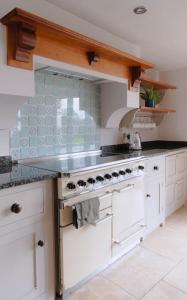 a kitchen with white cabinets and a stove top oven at The Old Sweet Shop, 4 Bedroom House 