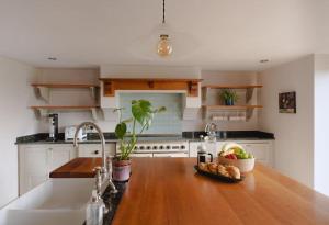 cocina con fregadero y encimera de madera en The Old Sweet Shop, 4 Bedroom House 