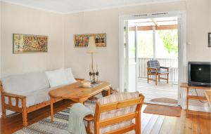 sala de estar con sofá y mesa en Cozy Home In motfors With Lake View en Åmotfors