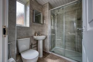 a bathroom with a toilet and a glass shower at Spacious 4 BR House w/Parking in Birmingham +50 photos