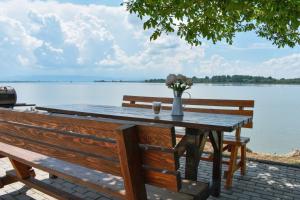 a wooden table with two benches and a view of a lake at Cabana Kia 