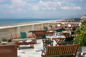 a balcony with chairs and tables and the beach at Palace Hotel in Viareggio