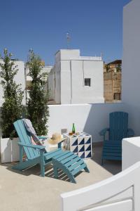 塔里法的住宿－El Escondite Tarifa，阳台上配有2把蓝色椅子和一张桌子