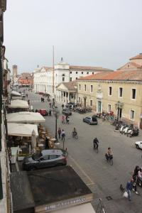a city street with people on bikes and cars at Patrizia Apartement in Chioggia