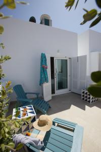 a living room with blue chairs and a table at El Escondite Tarifa in Tarifa +37 photos
