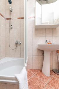 a bathroom with a white tub and a sink at Apartment Jelusic in Baška