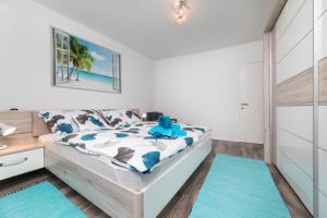 a bedroom with a bed with blue rugs at Apartment Jelusic in Baška