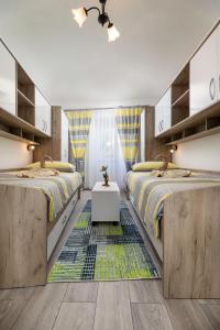 a bedroom with two beds and a rug at Apartment Jelusic in Baška
