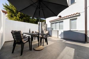 a patio with a table and chairs and an umbrella at Apartment Jelusic in Baška