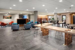 a lobby with tables and chairs and a fireplace at Courtyard by Marriott Seattle Northgate in Seattle