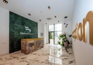 eine Lobby mit Steinboden und einer großen Wand in der Unterkunft White Sails Apartament in Batumi