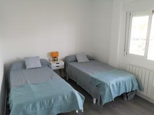 2 Einzelbetten in einem Zimmer mit Fenster in der Unterkunft Apartamento encantador con vistas al Club Naútico in Altea