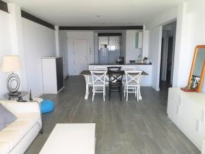 ein Wohnzimmer und eine Küche mit einem Tisch und Stühlen in der Unterkunft Apartamento encantador con vistas al Club Naútico in Altea