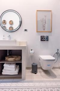 La salle de bains est pourvue d'un lavabo, de toilettes et d'un miroir. dans l'établissement Kassa Boutique Hotel, à Bethléem