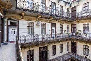 ブダペストにあるCharming Downtown Hideaway Steps from New York Café!のバルコニーと窓が備わる古い建物