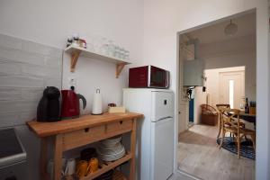 a kitchen with a white refrigerator and a microwave at Piccoleto Bianco in Badacsonytomaj