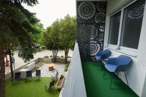 a balcony with blue stools and chairs on a building at Piccoleto Bianco in Badacsonytomaj