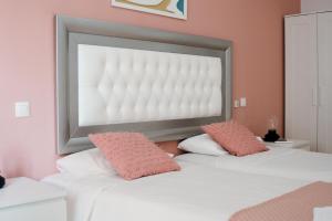 Resort Suites Vecindario في فيسينداريو: غرفة نوم بسريرين بجدران وردية