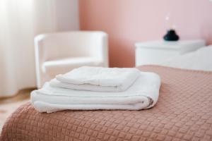 Resort Suites Vecindario في فيسينداريو: ثلاث مناشف بيضاء مكدسة على سرير