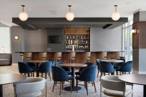 a restaurant with tables and chairs and a bar at Residence Inn by Marriott St Louis Clayton in Clayton