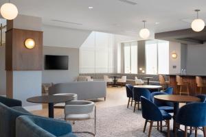 uma sala de espera com mesas e cadeiras em Residence Inn by Marriott St Louis Clayton em Clayton