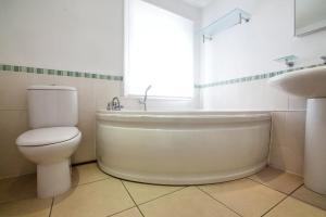 La salle de bains est pourvue de toilettes, d'une baignoire et d'un lavabo. dans l'établissement 2BR flat with roof terrace, à Londres