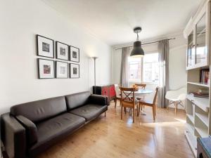 a living room with a black couch and a table at Casa Sagrada Familia in Barcelona