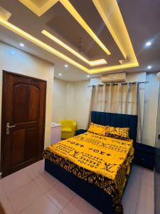 a bedroom with a bed with a yellow comforter at Apartment Diamant in Cotonou