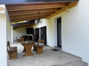 un patio con mesas de madera y sillas en un edificio en Active Chillax Oasis Apartments, en Ankaran