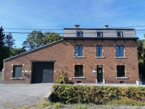 ein altes Backsteingebäude mit Garage in der Unterkunft Gite Terre de ciel in Ferrières