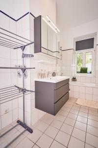 a white bathroom with a sink and a mirror at Gemütliche Ferienwohnung für die ganze Familie in Leipzig